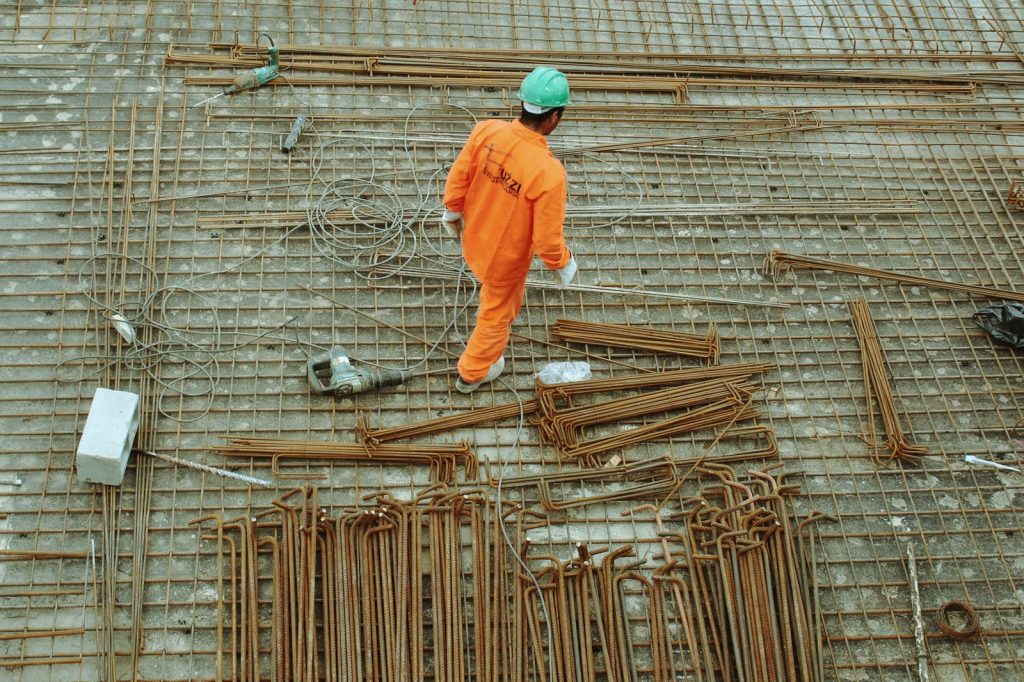 Hombre con traje naranja trabajando en una obra de construcción