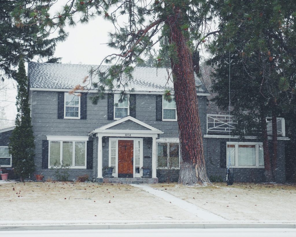 Casa gris y blanca con puerta roja